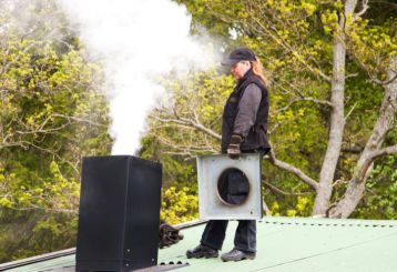 Professional chimney cleaner performing thorough maintenance.